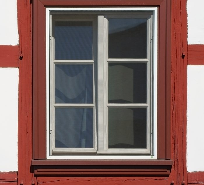 Rot gestrichenes Fachwerk mit weißem Sprossenfenster